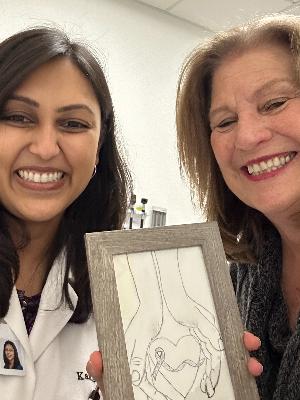 Dr. Nair (left) and Michele/Mom (right) joyfully hold my art created from the heart!